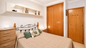 a bedroom with a bed and a wooden door at 2 bedroom flat 100m from the beach with huge terrace in Moncófar