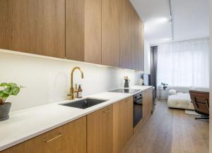 a kitchen with wooden cabinets and a sink at City Choice Apartment in Helsinki