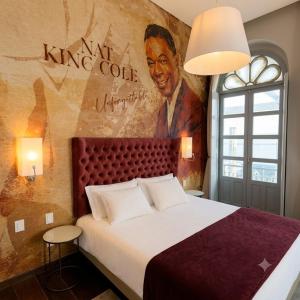 a bedroom with a large bed with a painting on the wall at Vila Galé Collection Opera - Sao Luis in São Luís +8 photos