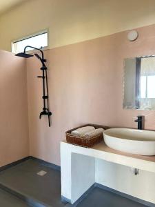 a bathroom with a sink and a large tub at Villa Soa in Nosy Be