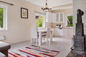 a kitchen with white chairs and a table and a stove at Lobrothaugen in Fagernes +3 photos
