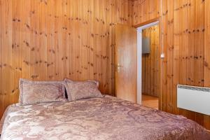 a bedroom with a bed with wooden walls at Lobrothaugen in Fagernes