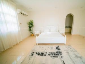 a white bedroom with a bed and a rug at Hideout Farmhouse - By Seven Elements in Ras al Khaimah +44 photos