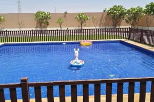 a person playing in a pool with a frisbee at Hideout Farmhouse - By Seven Elements in Ras al Khaimah