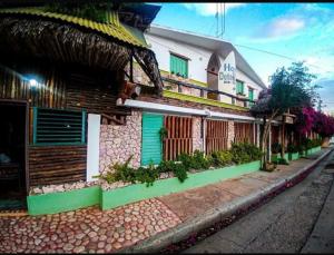 a building with green doors on a street at Hostal Doña Chava in Pedernales