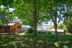 a wooden cabin with a fence and two benches at Raíces da Costa Ártabra in Islote Mouron