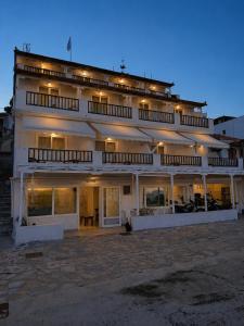 a large white building with lights on it at Pansion Nikos in Patitiri