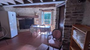 a living room with a table and a fireplace at Le Moulin des Salces in Saint-Privat