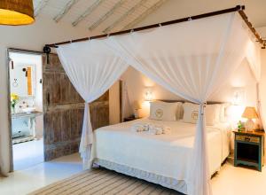 a bedroom with a bed with a canopy at Casa La Torre Hotel Boutique in Trancoso +38 photos