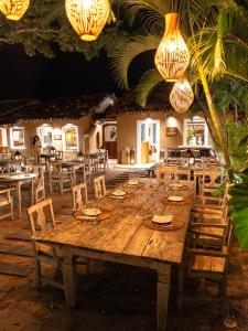 a large wooden table and chairs in a restaurant at Casa La Torre Hotel Boutique in Trancoso