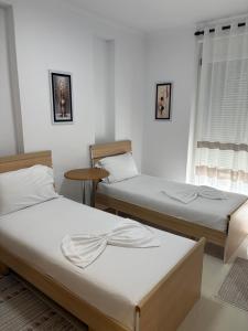 a room with two beds and a window at Shtepi ditore elbasan in Elbasan