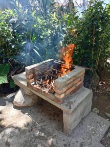 a fire pit sitting on top of a stone bench at Acogedora cabaña Hospedaje Mérida in Mérida