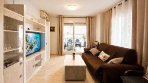 a living room with a couch and a tv at 2 bedroom flat 100m from the beach with huge terrace in Moncófar