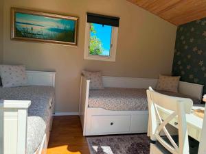 a small bedroom with two beds and a window at Stuga 1 Lillstugan in Ängelholm