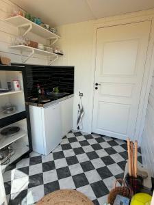 a kitchen with a black and white checkered floor at Stuga 1 Lillstugan in Ängelholm