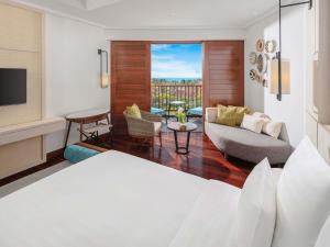 a bedroom with a bed and a living room at Pullman Danang Beach Resort in Danang
