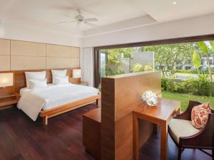 a bedroom with a bed and a table and chairs at Pullman Danang Beach Resort in Danang +251 photos