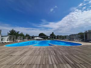 a large blue swimming pool with a wooden deck at Rancho Otel Almaty in Qaskeleng