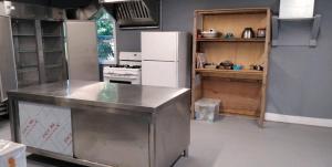 a kitchen with a white refrigerator and a stove at EcoSun Hostel in Montague