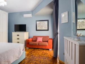 a bedroom with a bed and a red chair at Villa Francesca Luxury Rooms in San Demetrio Corone