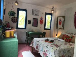 a room with a bed and a table and windows at Canto Alegre Pernambuco in Goiana
