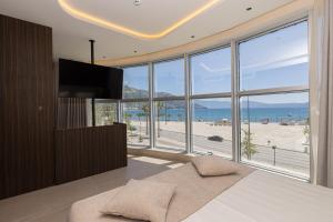 a bedroom with a bed with a view of a beach at Quartz Hotel Vlore in Vlorë