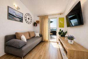 a living room with a couch and a tv at Apartman Štorija with Private Jacuzzi-Brela in Brela