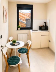 a small kitchen with a table and chairs in a room at Apartmani Sjenjak Prestige in Tuzla +29 photos