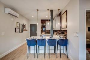 a kitchen with a table and blue stools at Chic Tennyson St Retreat - Walk to Shops & Cafes in Denver
