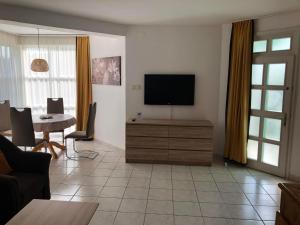 a living room with a flat screen tv on a cabinet at Greenhouse Apartman in Zalakaros