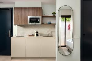 a kitchen with a sink and a mirror at AZUL HOME SUITES Estepona in Estepona