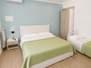 a small bedroom with two beds and a night stand at Riviera AlbaChiara B&b in Anzio