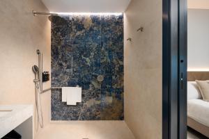 a bathroom with a shower with a blue wall at AZUL HOME SUITES Estepona in Estepona
