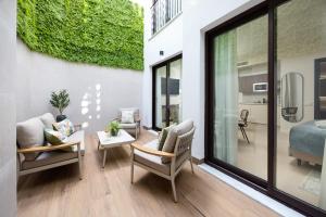 a living room with a bed and a couch and chairs at AZUL HOME SUITES Estepona in Estepona +53 photos