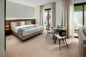 a bedroom with a bed and a table and chairs at AZUL HOME SUITES Estepona in Estepona