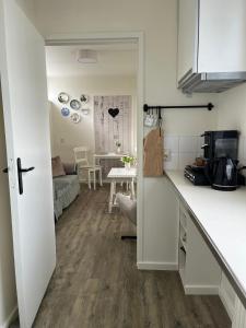 a kitchen and a living room with a table at B&B Bij Kaatje Thuis in Emmen