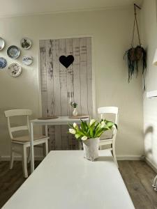a table and chairs with a table and a vase with a plant at B&B Bij Kaatje Thuis in Emmen +4 photos