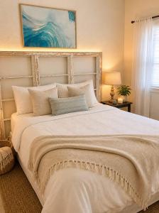 a bedroom with a large white bed with pillows at Oranje Air B&B in Alexander Bay