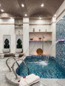 a swimming pool with a fountain in a hotel room at Dar Lala Fatma in Le Lido