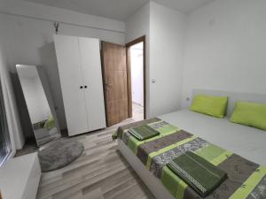 a bedroom with a bed with a green blanket at N&L apartments in Strumica
