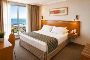 a hotel room with a bed with a view of the ocean at Alto del Sol Costanera Antofagasta in Antofagasta