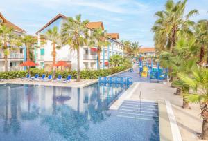 a pool at a resort with chairs and palm trees at Decameron Isleño - All Inclusive in San Andrés +25 photos