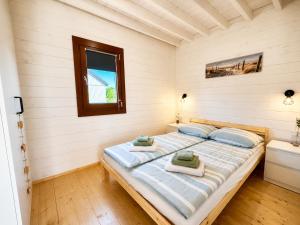 a bedroom with a bed with towels on it at KOPA LIVING seaside holiday homes in Nida +24 photos