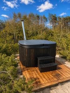 a hot tub sitting on a wooden deck at KOPA LIVING seaside holiday homes in Nida