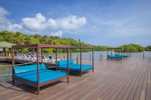 a wooden pier with blue benches on the water at Decameron Marazul - All Inclusive in San Andrés