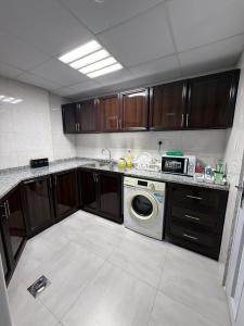 a kitchen with a washing machine and a microwave at Royal International in Abu Dhabi +7 photos