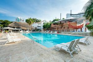 a swimming pool with lounge chairs and a pirate ship at Decameron Galeon - All Inclusive in Santa Marta