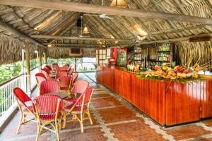 a restaurant with red chairs and a counter with a bar at Decameron Galeon - All Inclusive in Santa Marta