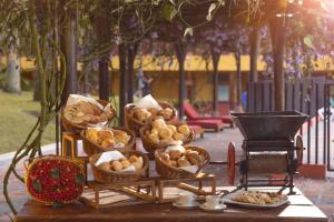 a table with baskets of bread and other food on it at Decameron Panaca - All Inclusive in Quimbaya