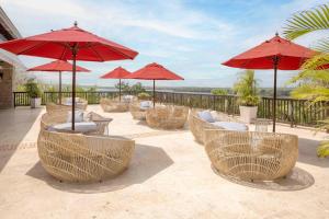 a group of tables and chairs with red umbrellas at Decameron Barú - All Inclusive in Playa Blanca